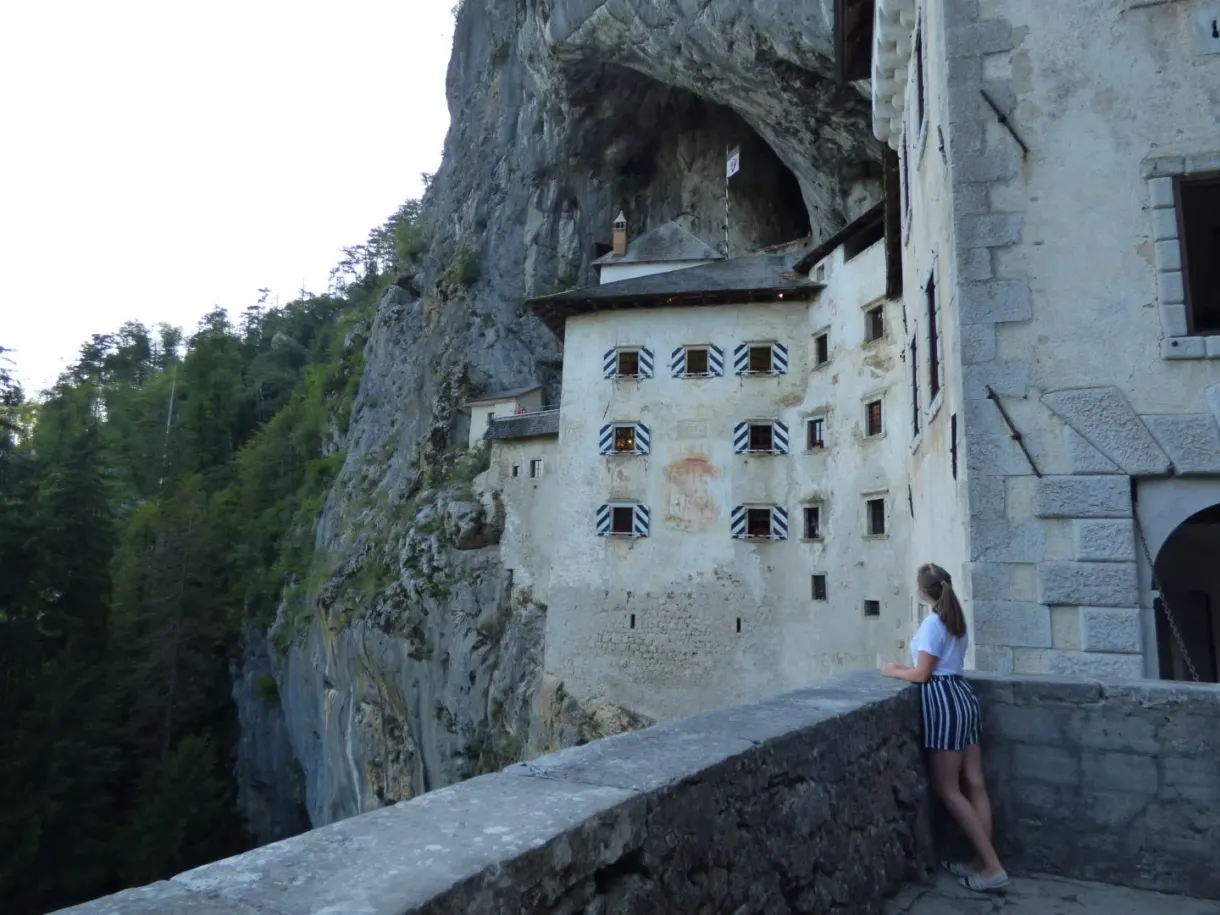 Woman leaning against the castle wall beneath the rock vault