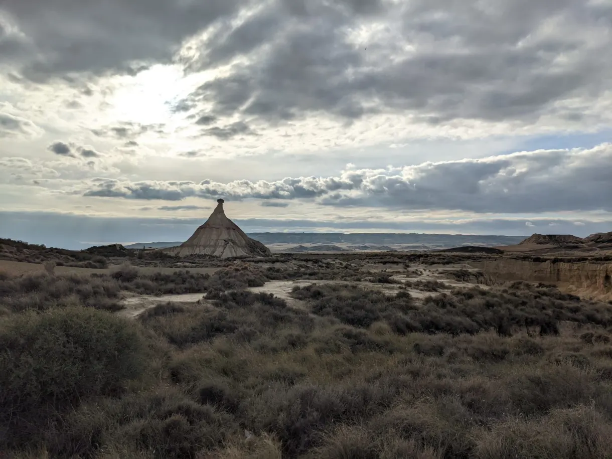 Cheminée rocheuse au loin sous un ciel de nuages gris