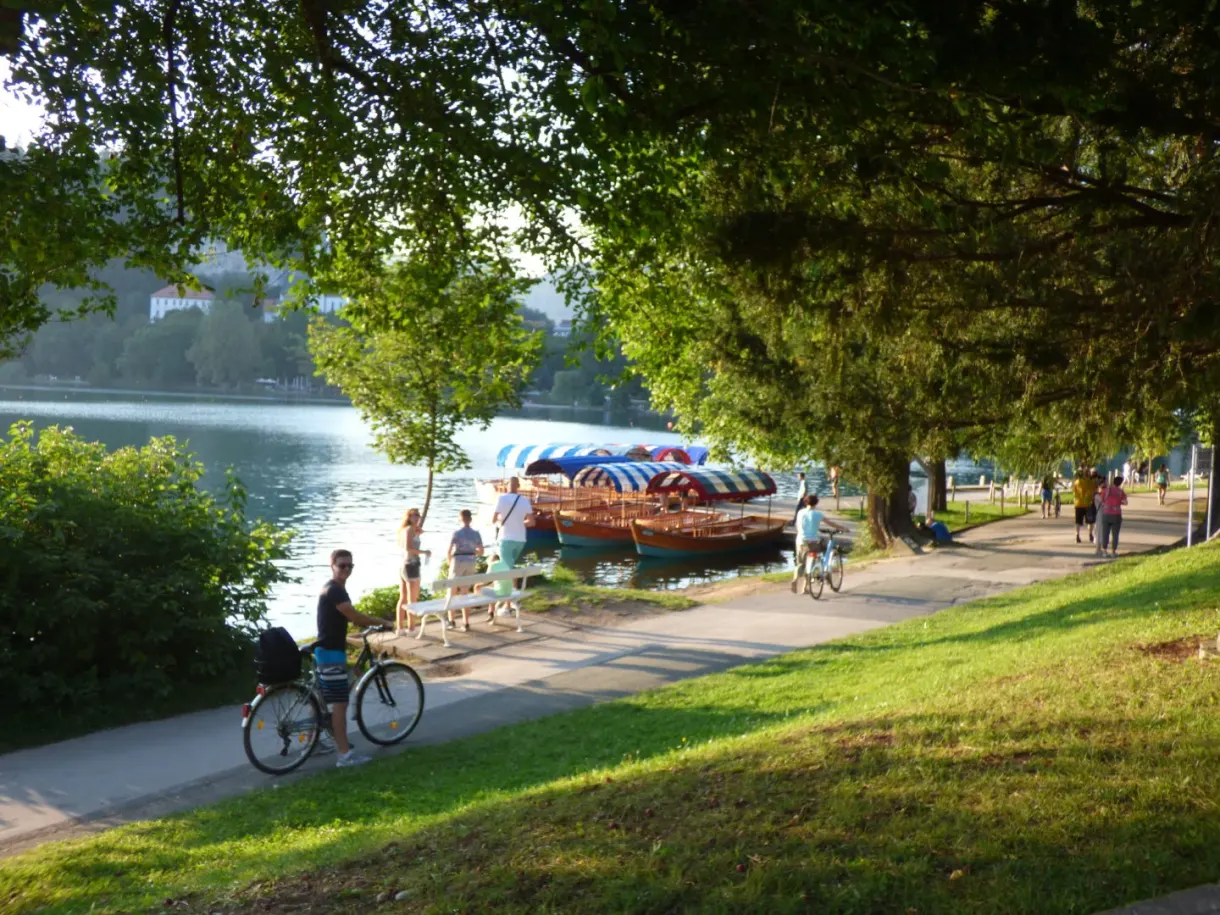 Chemin ombragé du tour du lac, barques et cyclistes