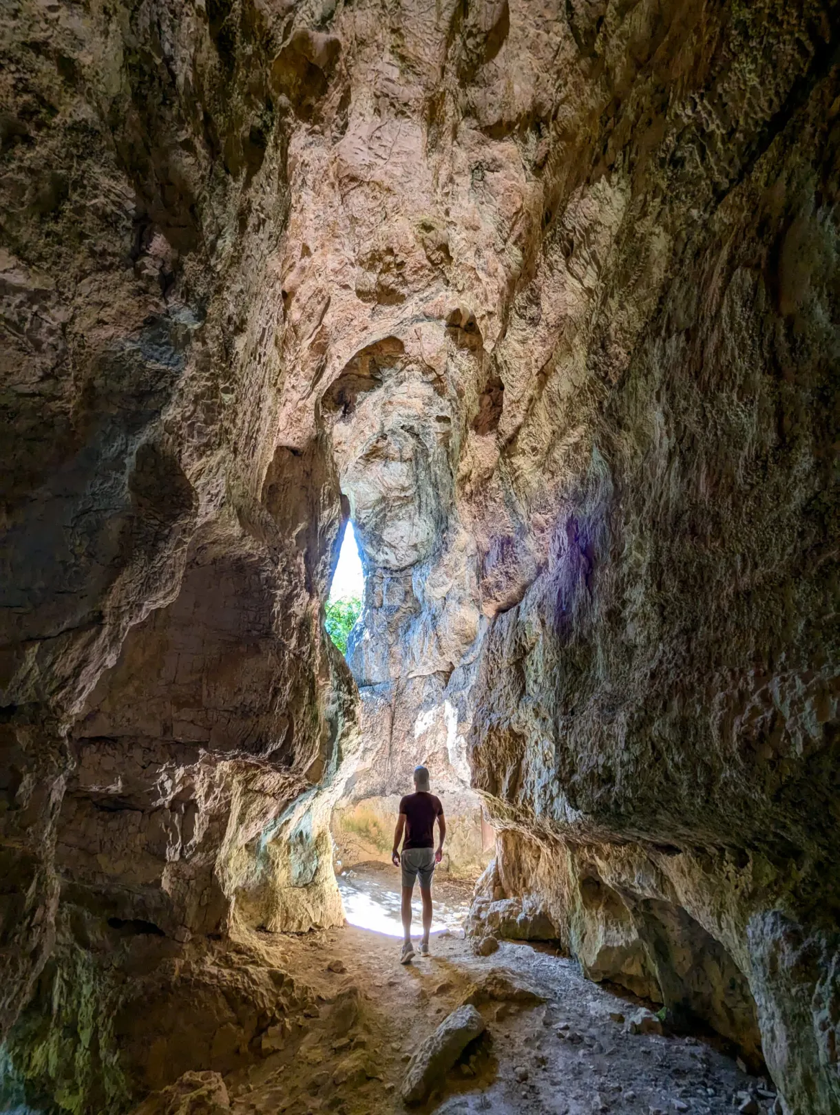 Silhouette d'un marcheur dans la vaste grotte éclairée