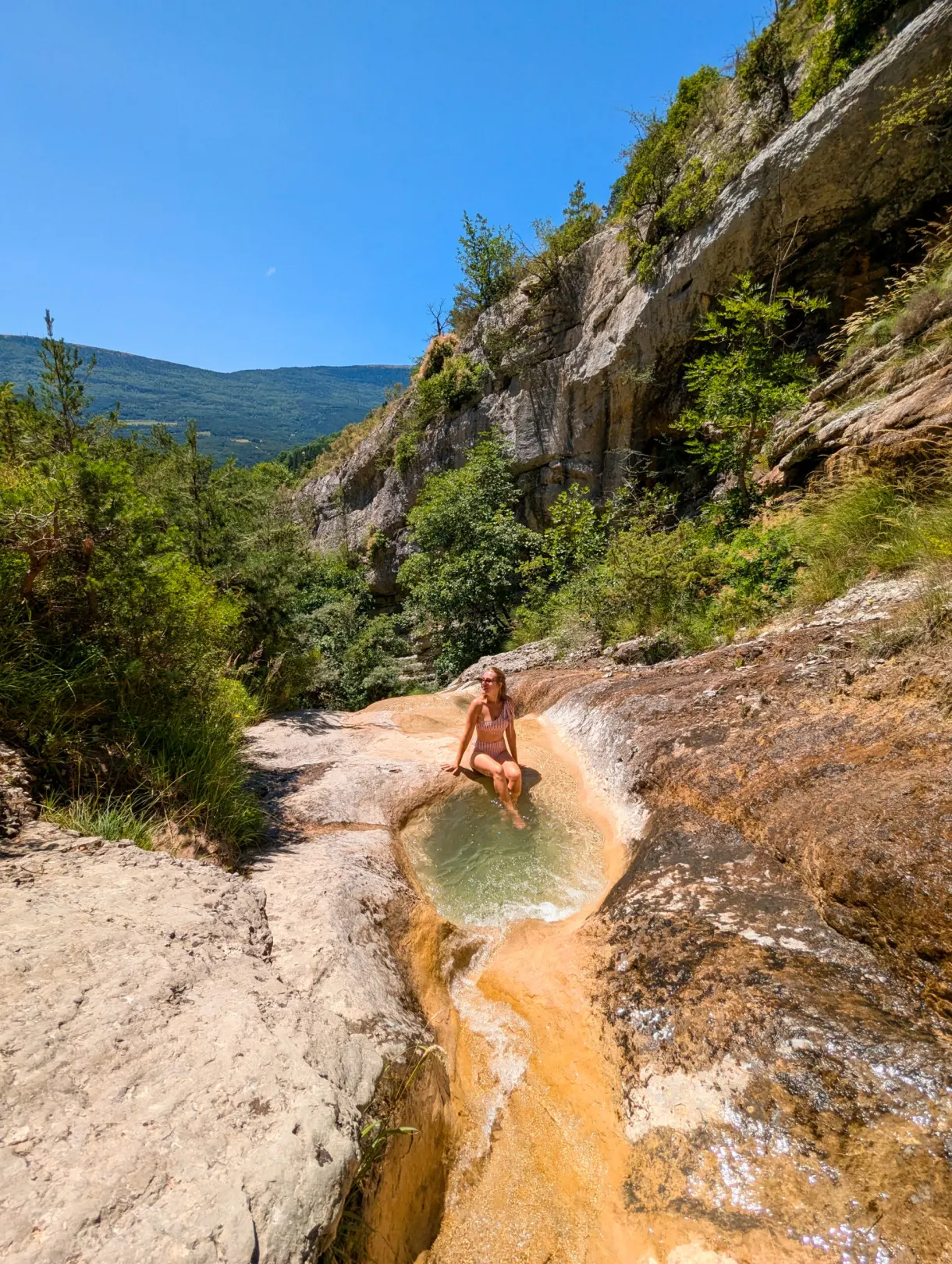 Marie dans une vasque naturelle au pied des falaises, dans le pays des Sources du Buëch