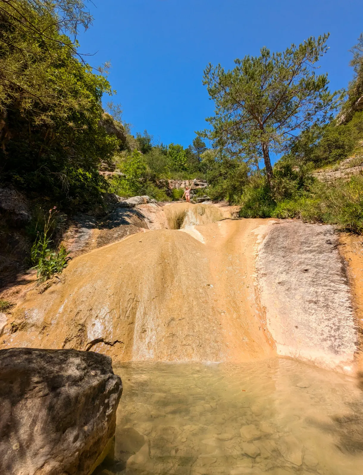 Toboggan de roche ocre poli par l'eau qui ruisselle