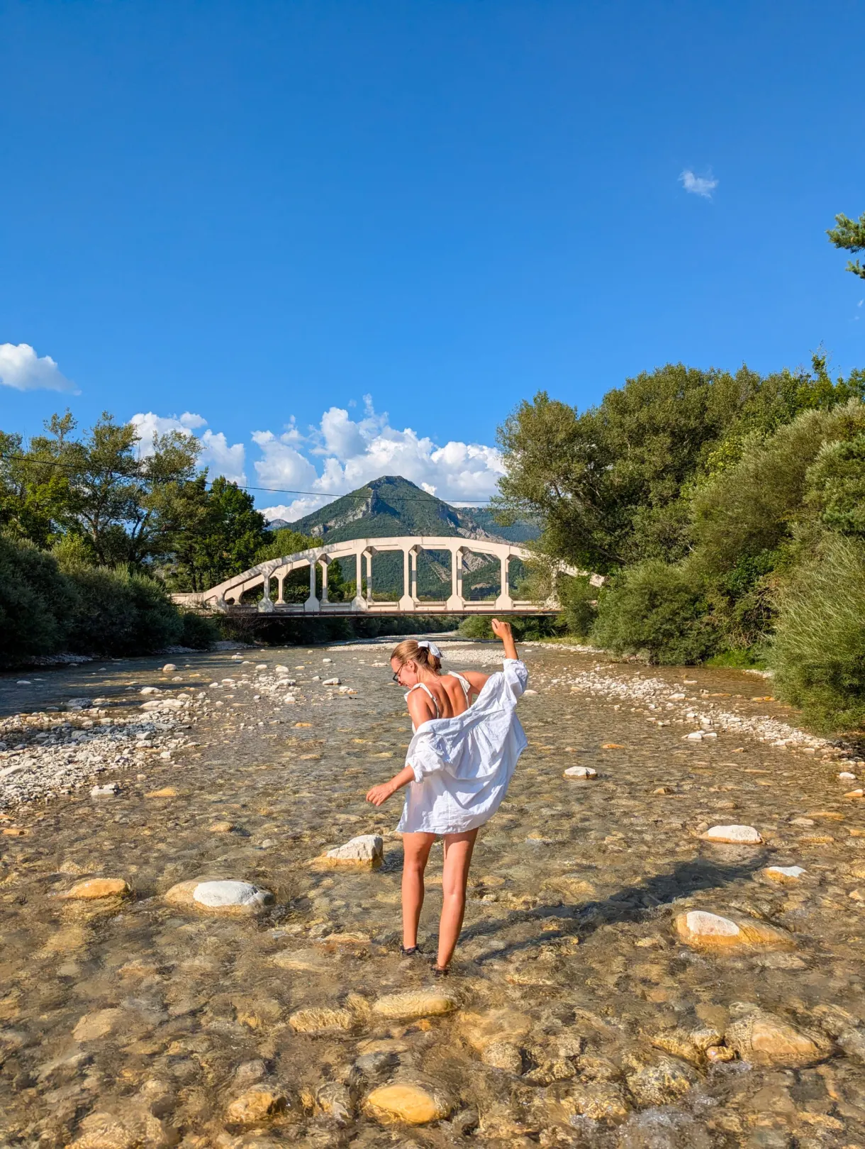 Baigneuse debout sur les galets du lit de la rivière