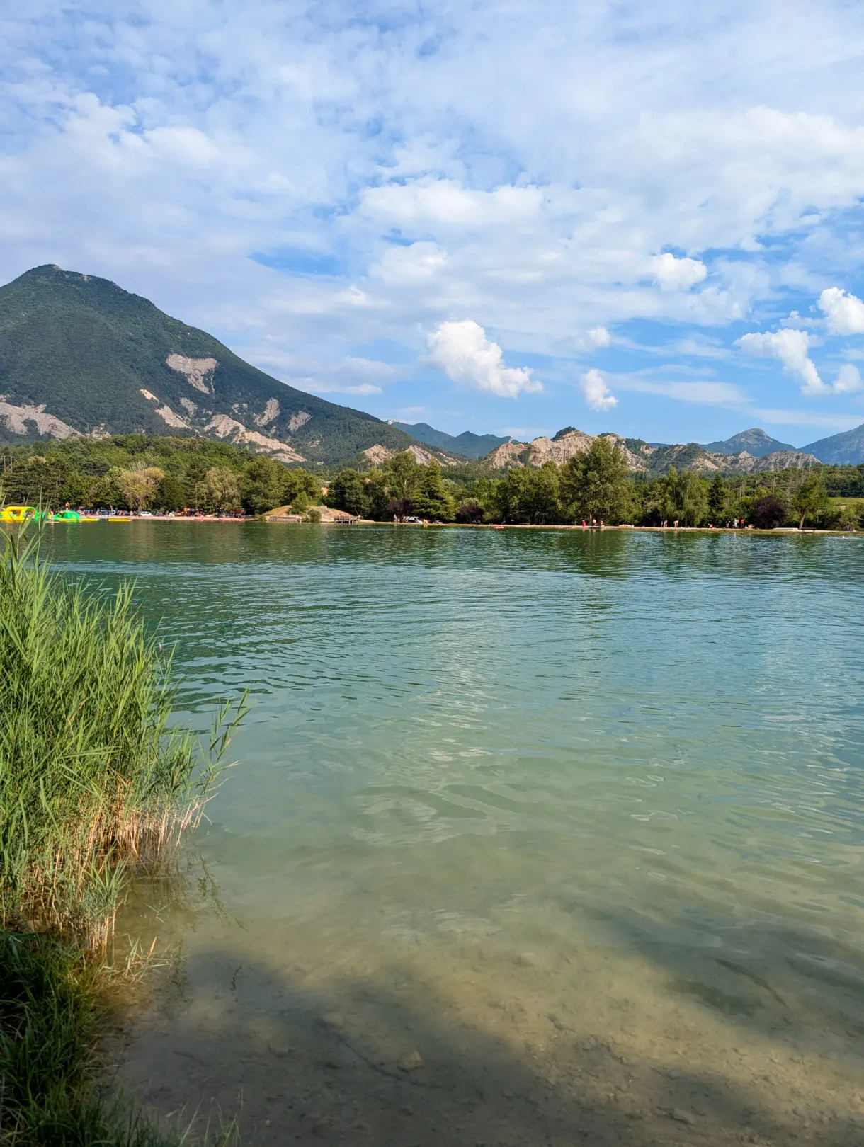 Plan d'eau bordé de roseaux avec la montagne en arrière-plan