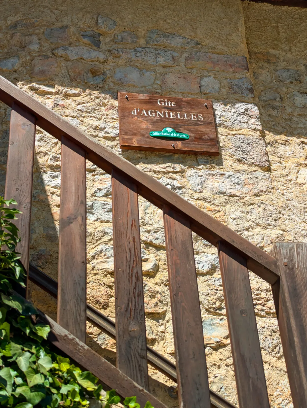 Panneau du gîte d'Agnielles au-dessus d'un escalier de bois