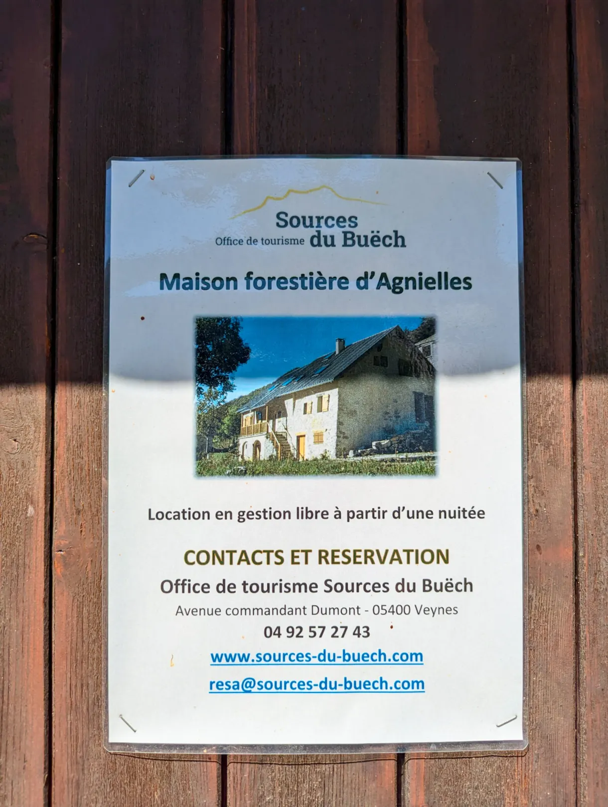 Affiche de location de la maison forestière punaisée sur la porte