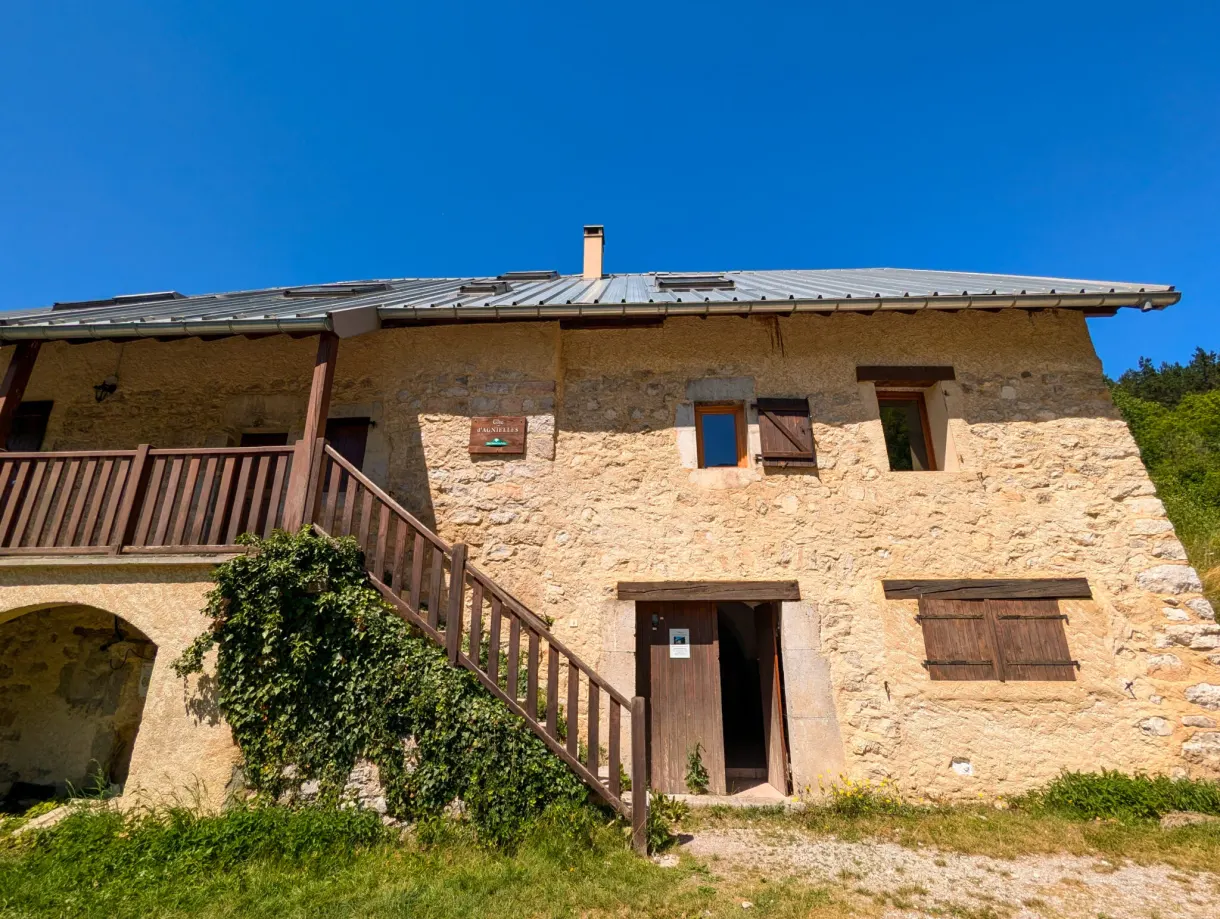 Bâtisse de pierre à escalier extérieur et balcon de bois