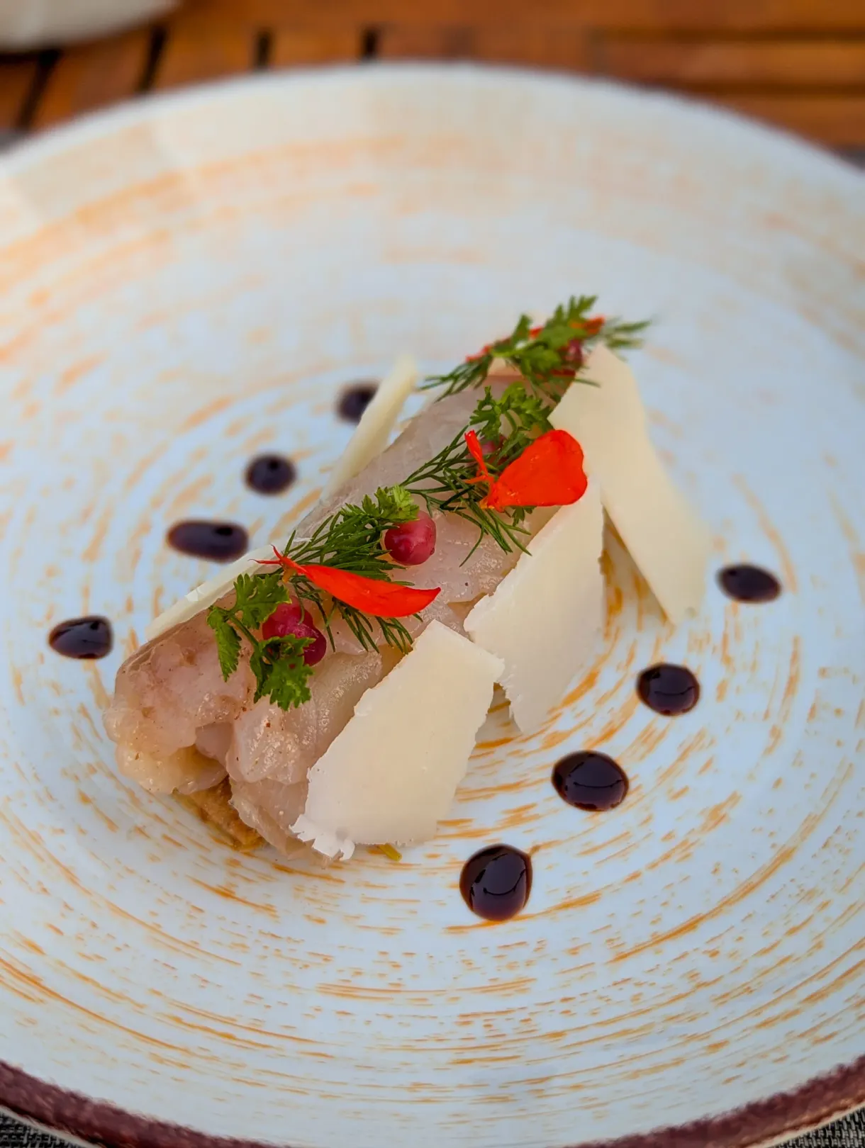 Carpaccio garni de copeaux de fromage et de fleurs comestibles
