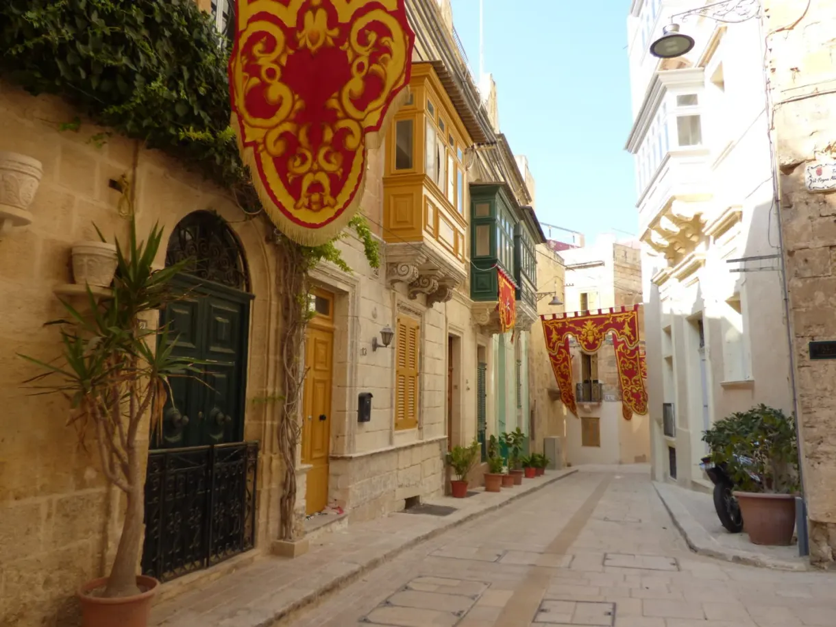 Ruelle en pente ornée de tentures et de balcons fermés