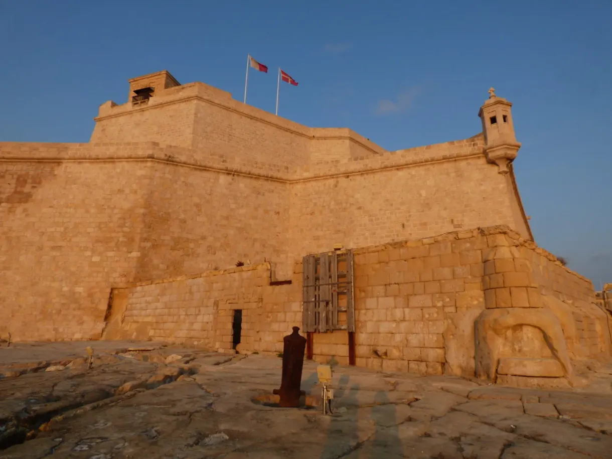 Bastion de pierre dorée et drapeaux au soleil couchant