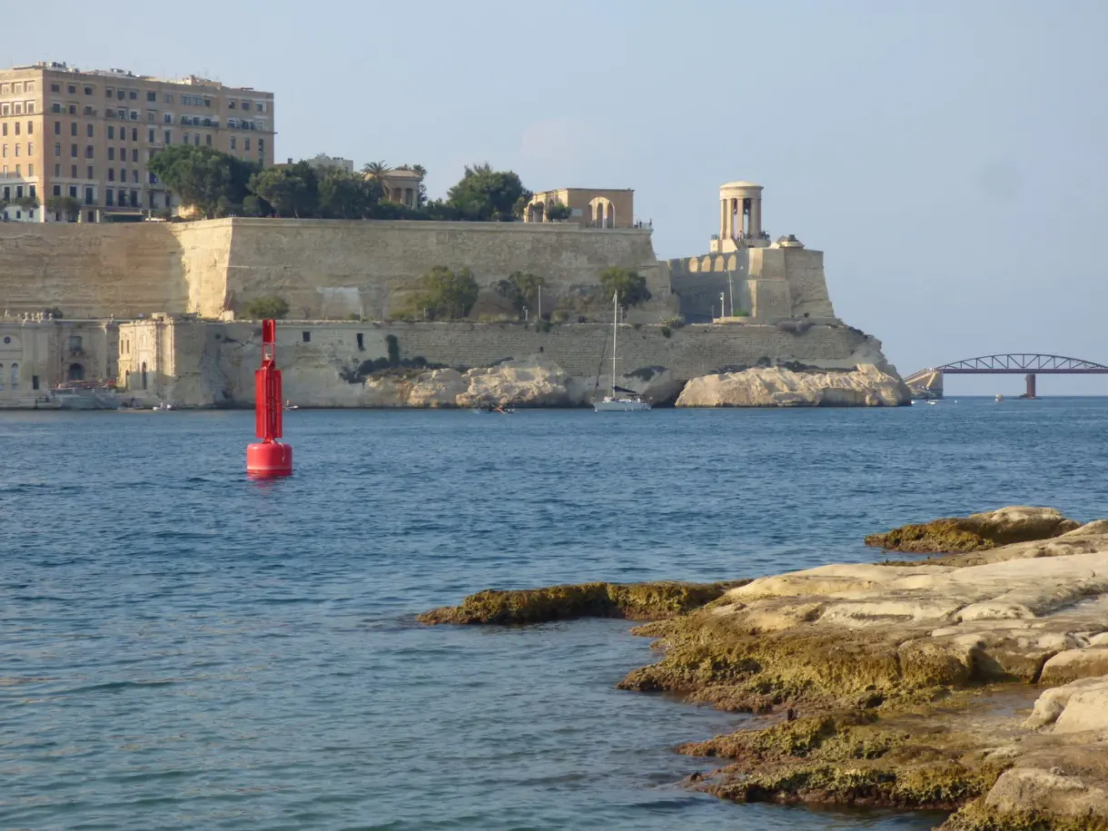 Pointe fortifiée et bouée rouge au ras des rochers
