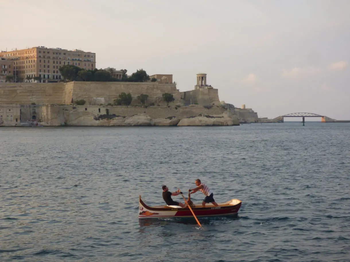 Deux rameurs dans une barque devant les fortifications