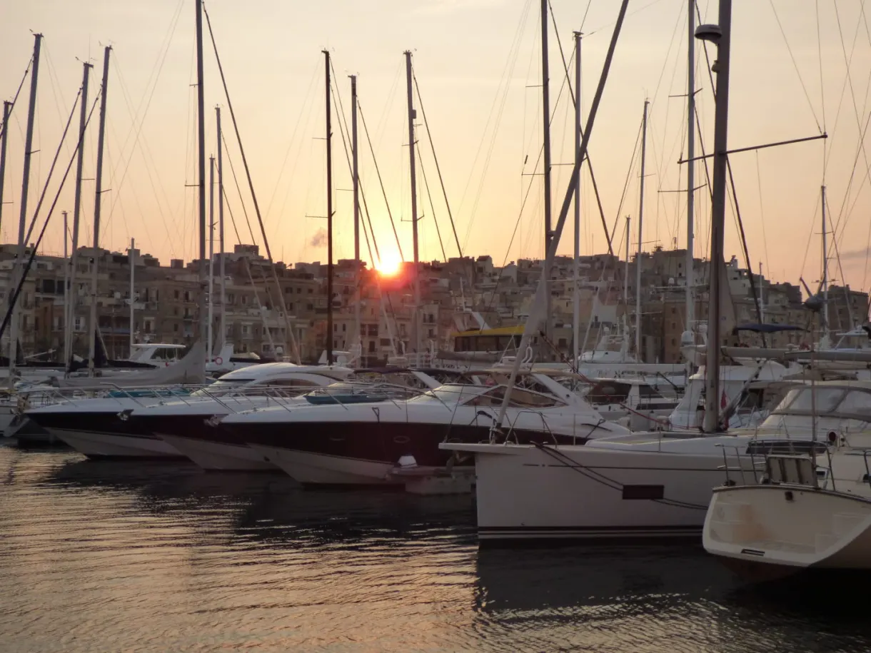 Soleil couchant filtrant entre les mâts des voiliers