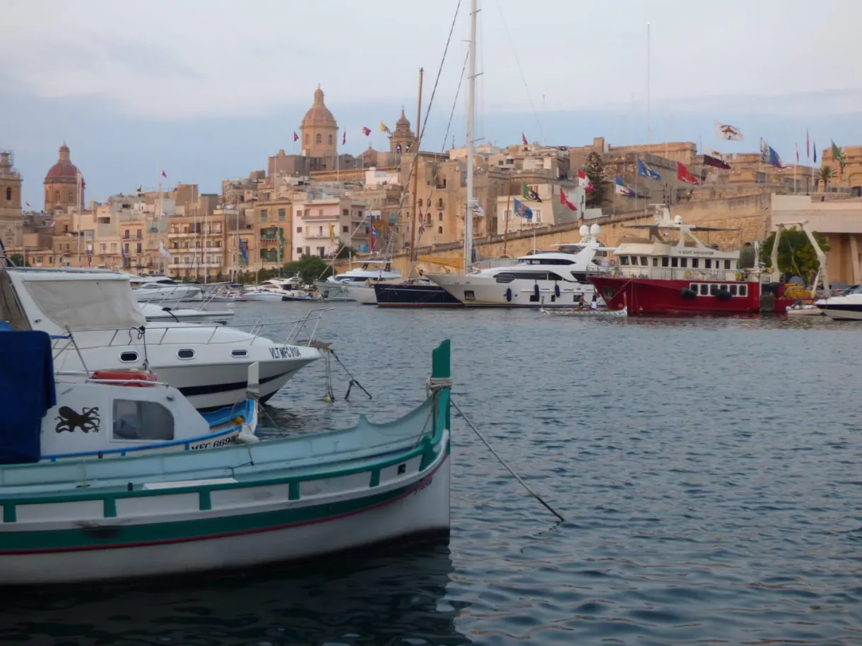 Barque maltaise devant les dômes et les façades dorées