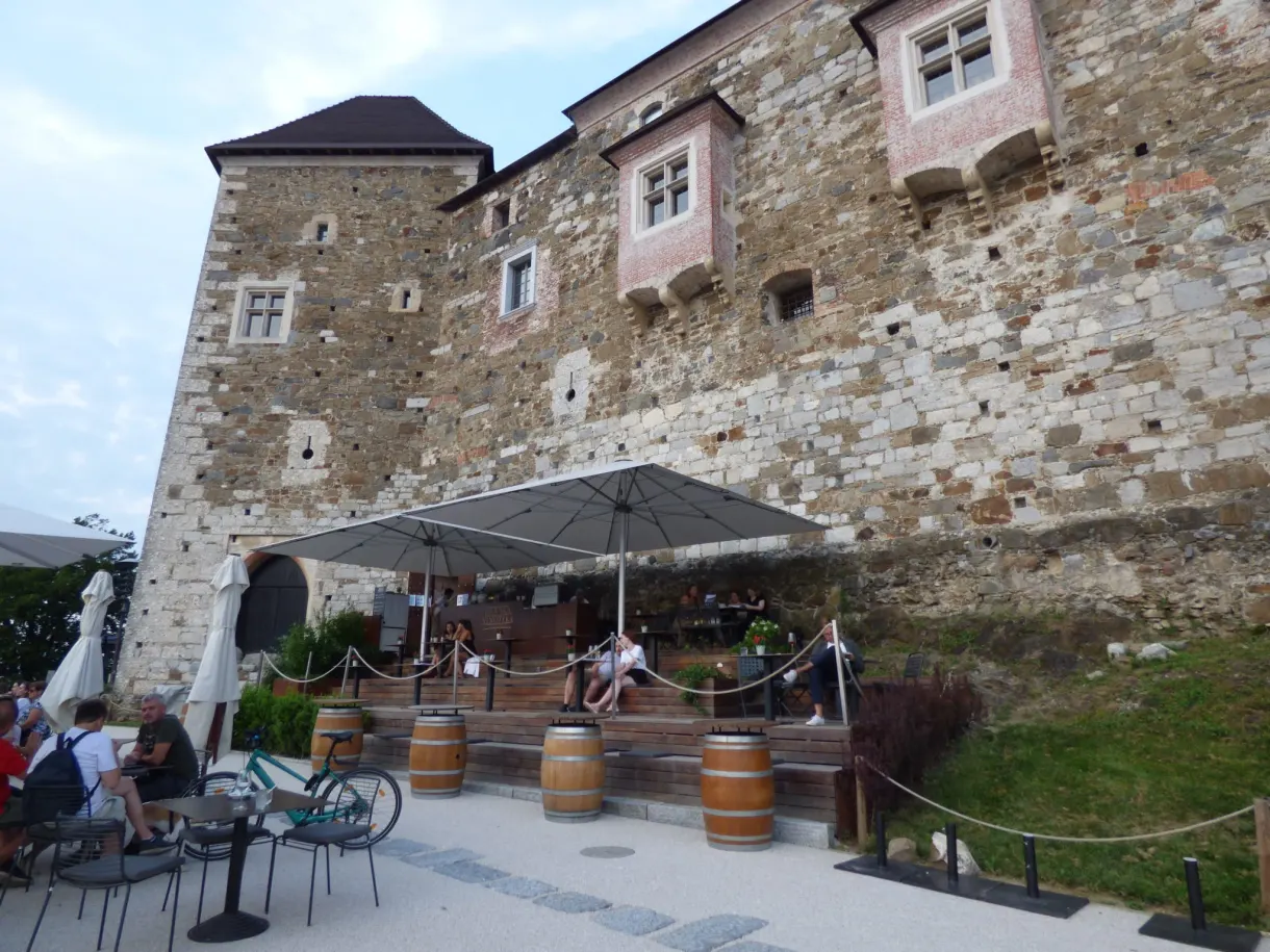 Terrasse à parasols et tonneaux installée au pied des murs