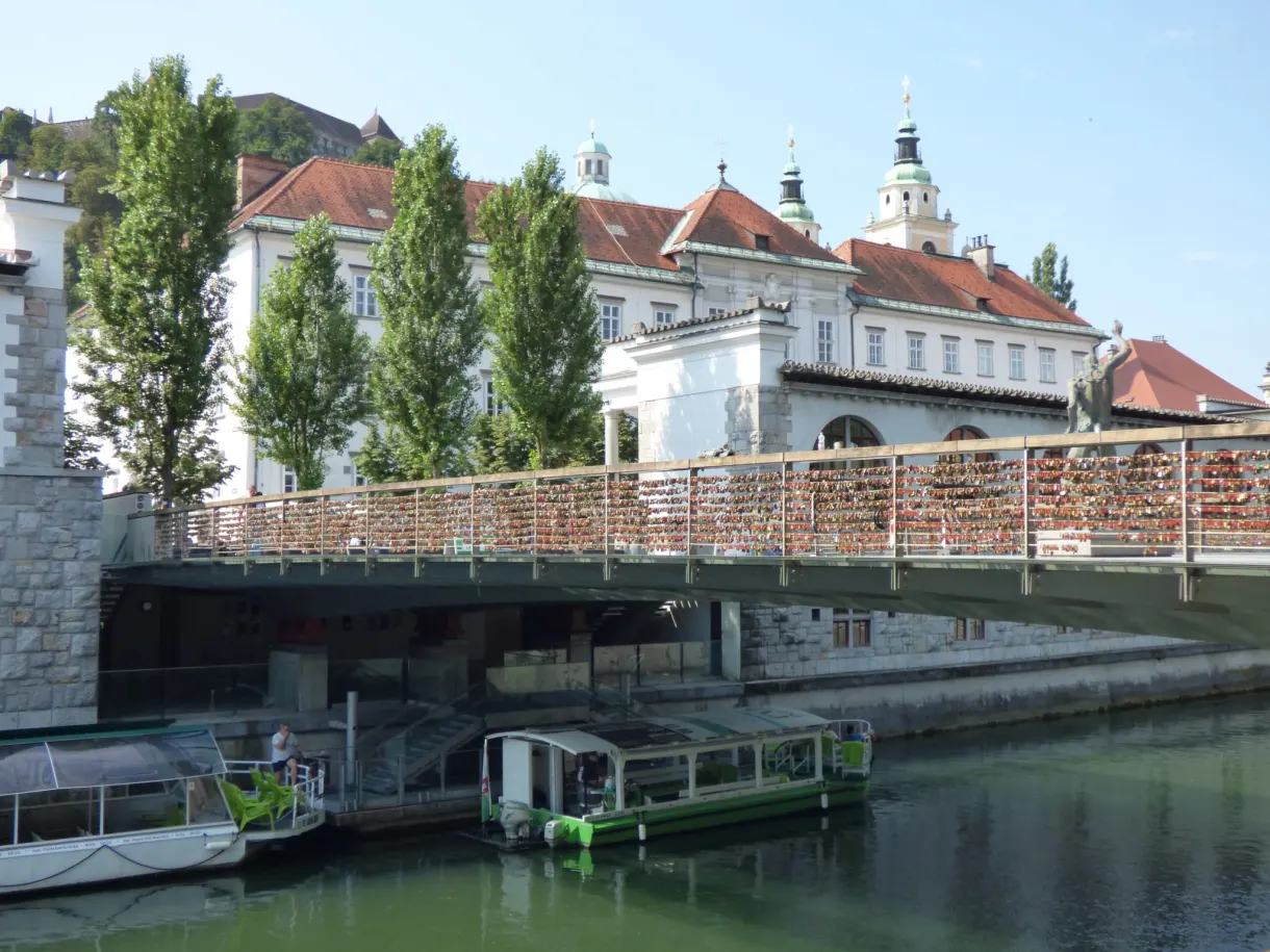 Bateau-promenade amarré sous un pont métallique de la Ljubljanica