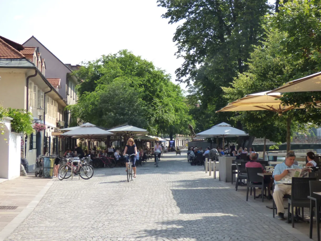 Terrasses ombragées et cyclistes sur le quai piéton
