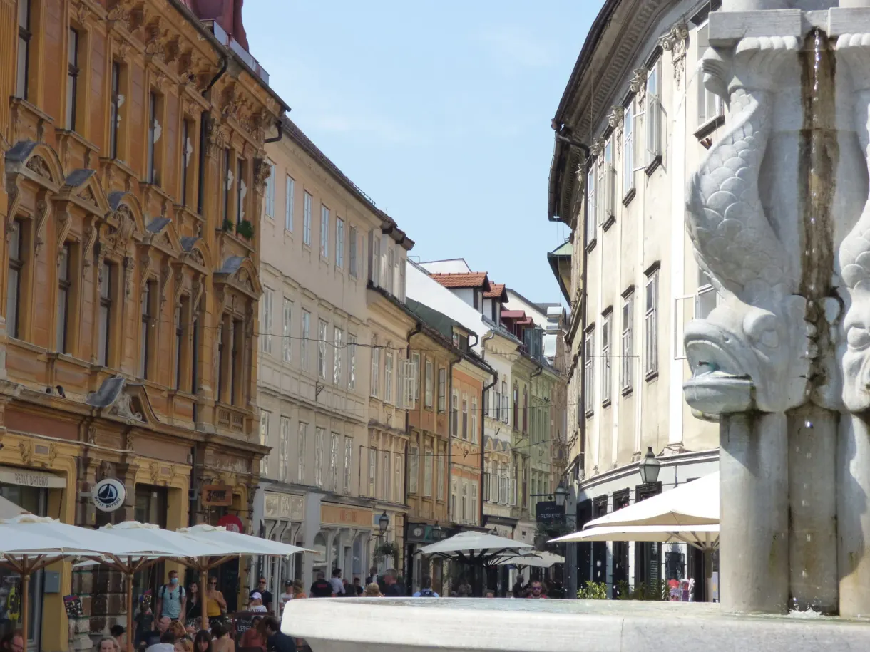 Fontaine sculptée et terrasses à parasols blancs entre les palais