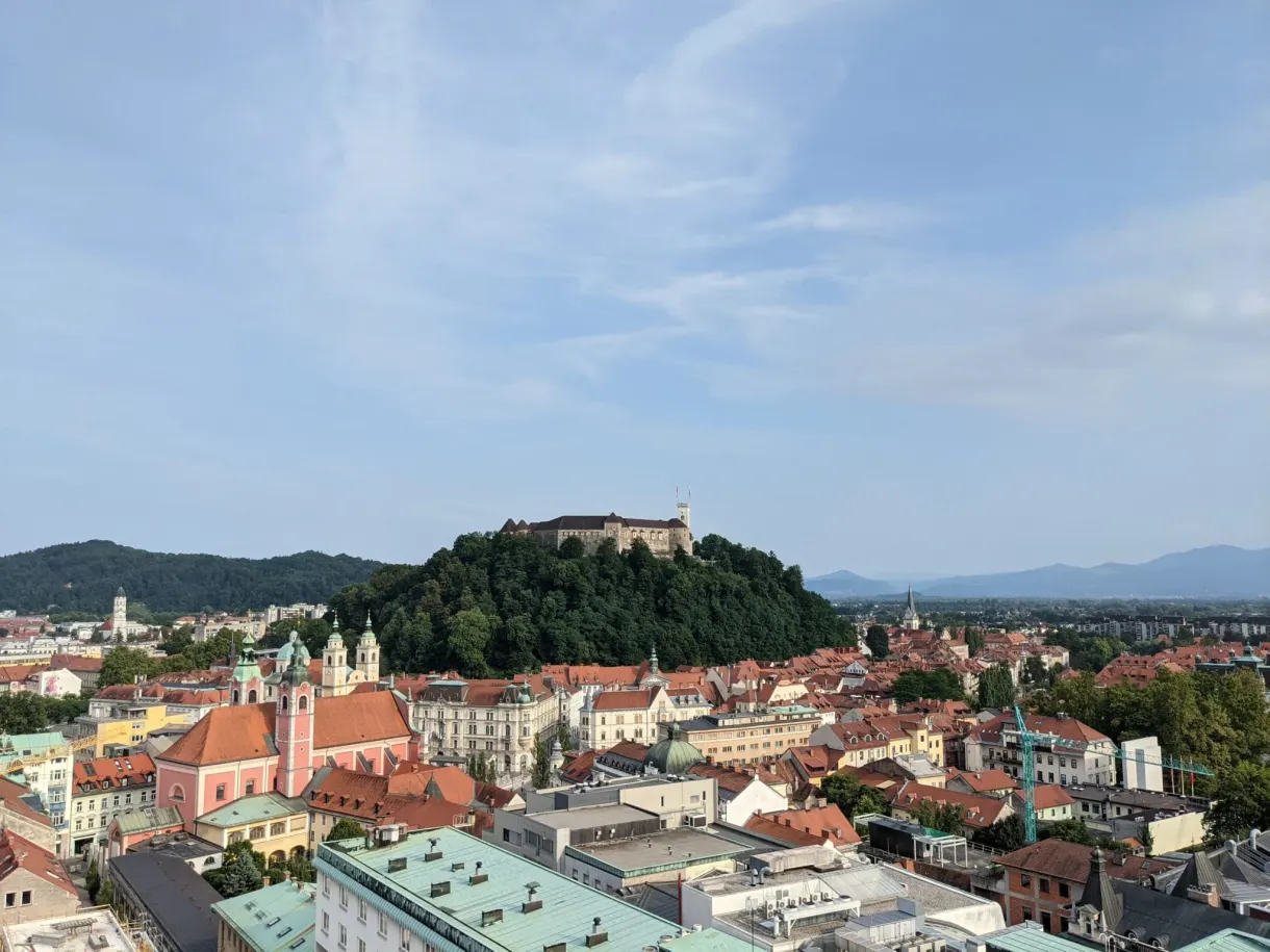 Château dominant les toits rouges depuis un balcon en hauteur