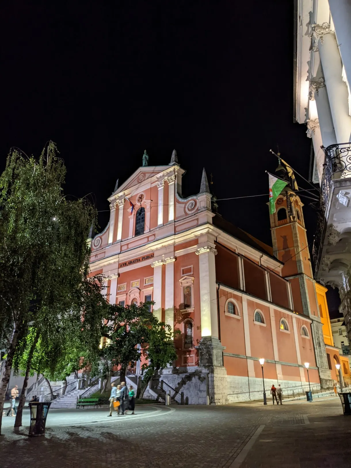 Église rose éclairée la nuit au-dessus des escaliers