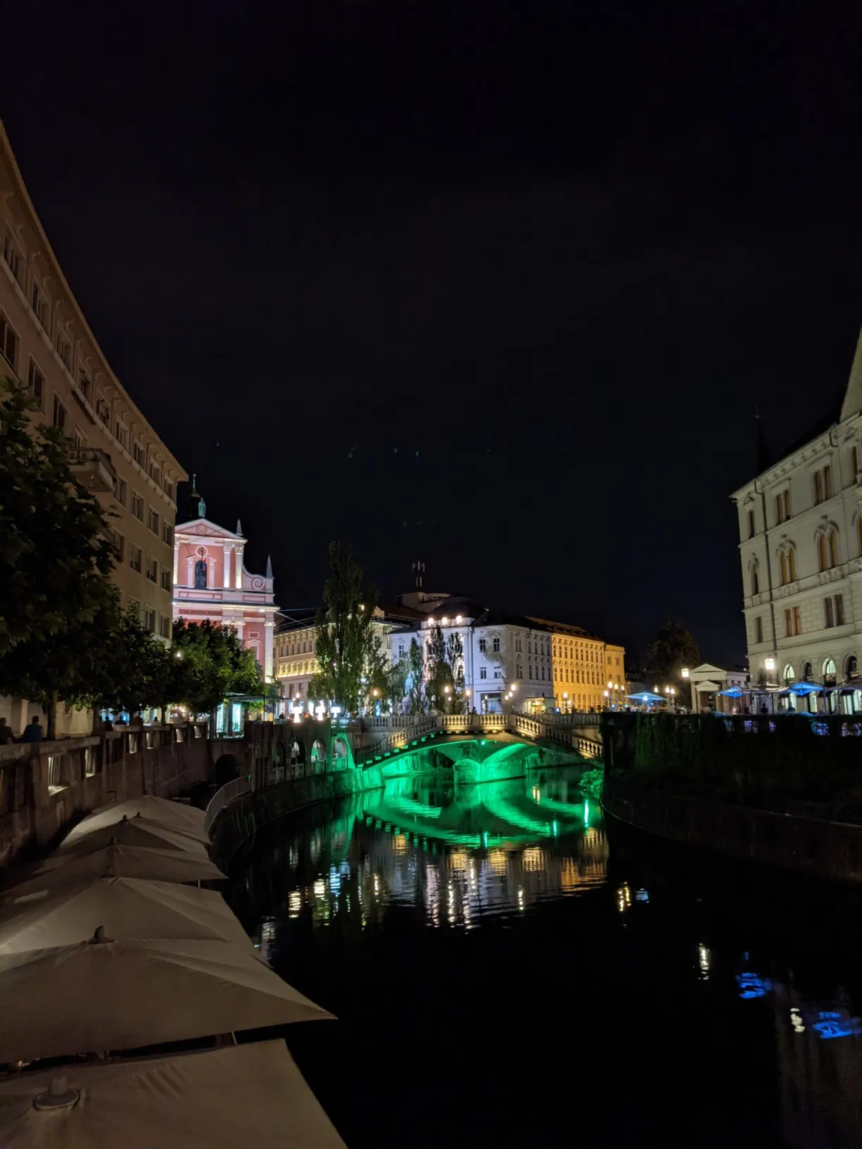 Lumière verte du pont se reflétant sur la rivière nocturne