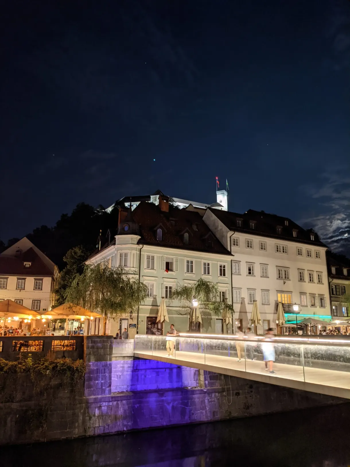 Château illuminé au-dessus des terrasses éclairées du quai