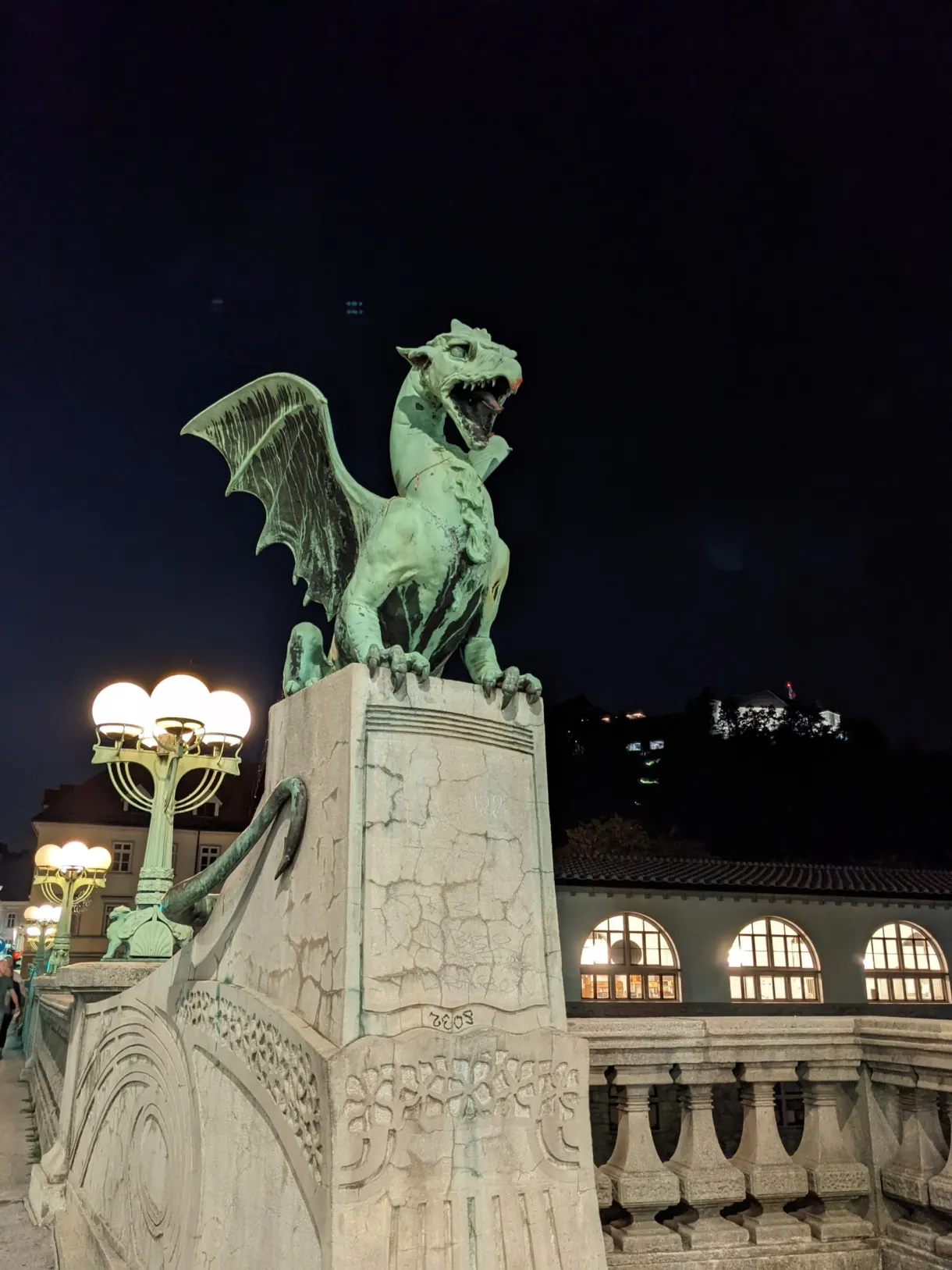 Dragon de bronze du pont sous les lampadaires allumés