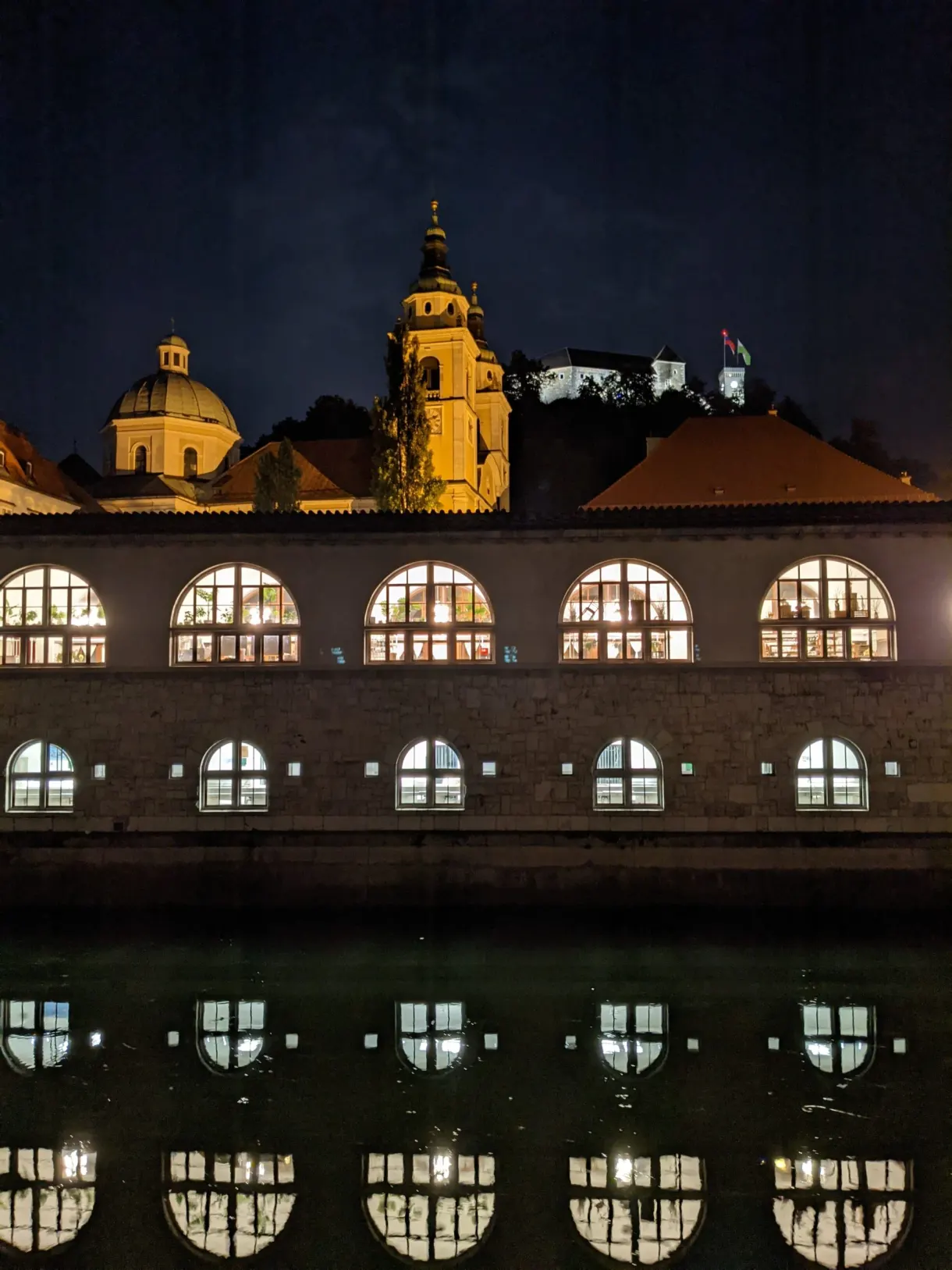 Arcades des halles doublées par leur reflet dans l'eau noire