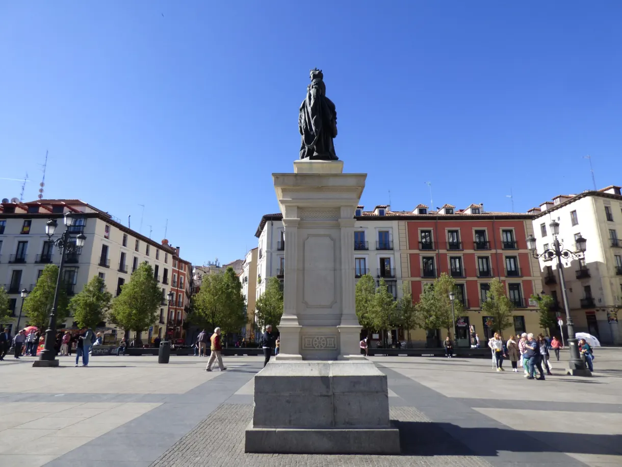 Statue sur son haut socle au centre d'une place ensoleillée