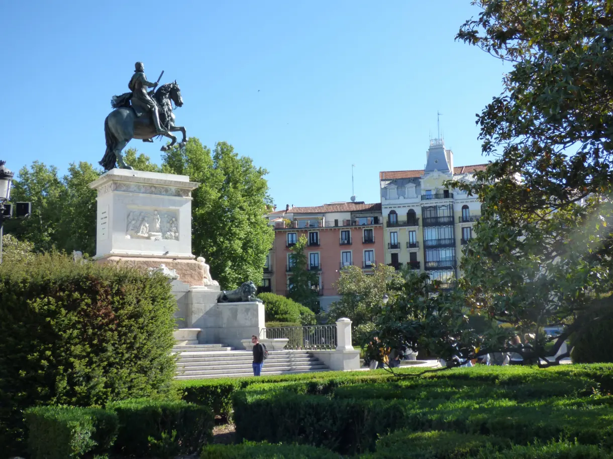 Cavalier de bronze dominant un jardin planté d'arbres