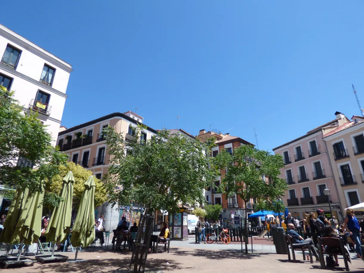 Terrasses et parasols repliés sur une place animée