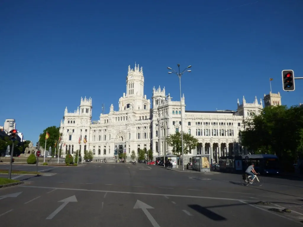 Palais blanc de Cibeles au bout d'une avenue déserte