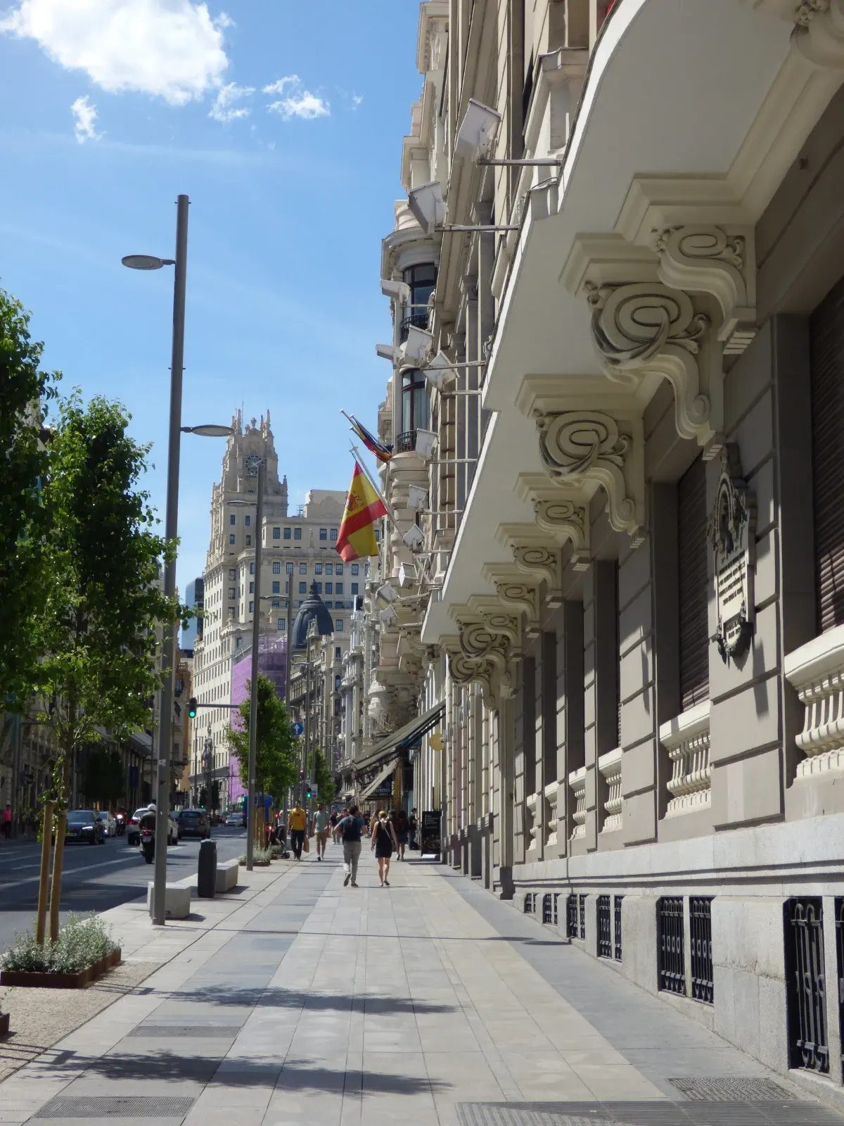 Trottoir ensoleillé longeant de hautes façades ouvragées