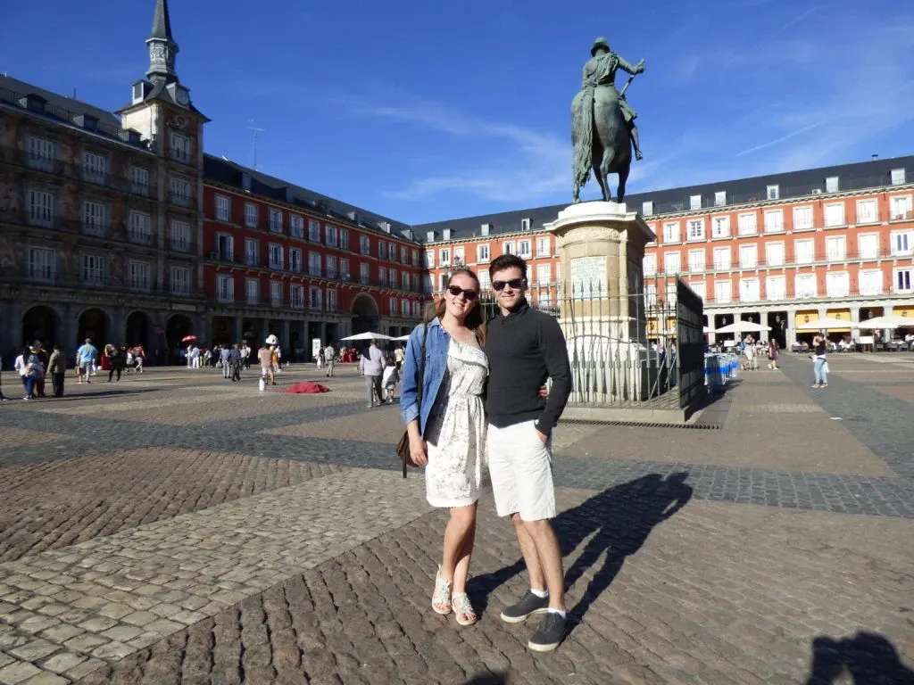 Couple posant devant la statue équestre de la Plaza Mayor