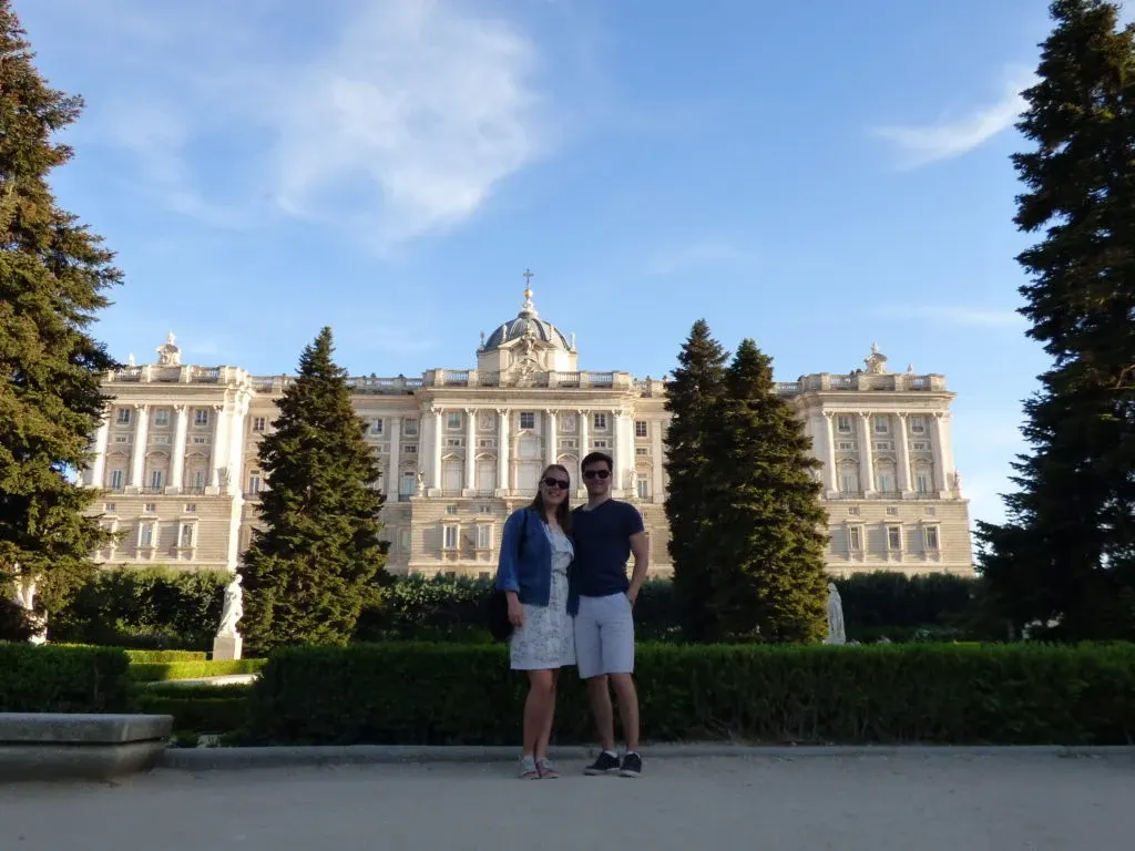 Couple devant la longue façade claire du palais royal