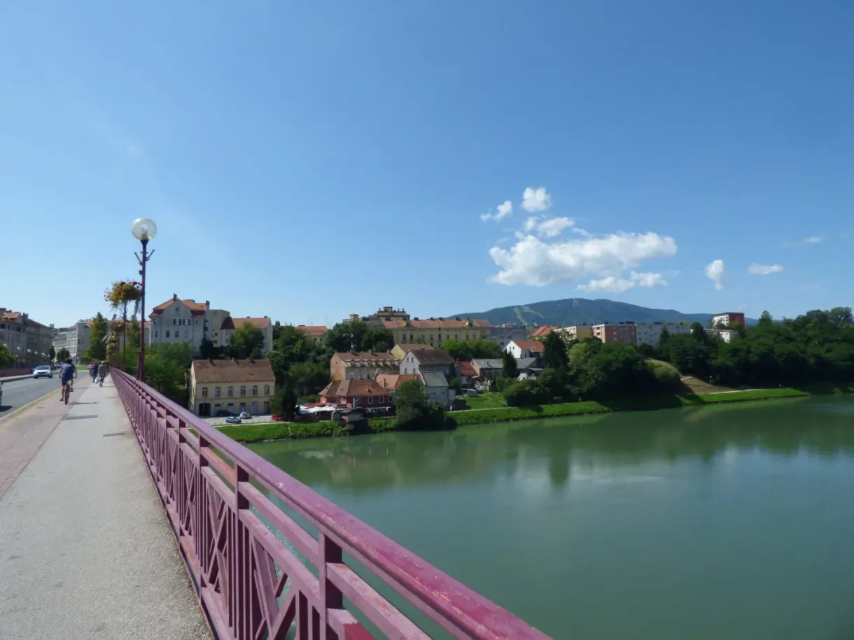 Depuis un pont rose, la rivière et les collines boisées