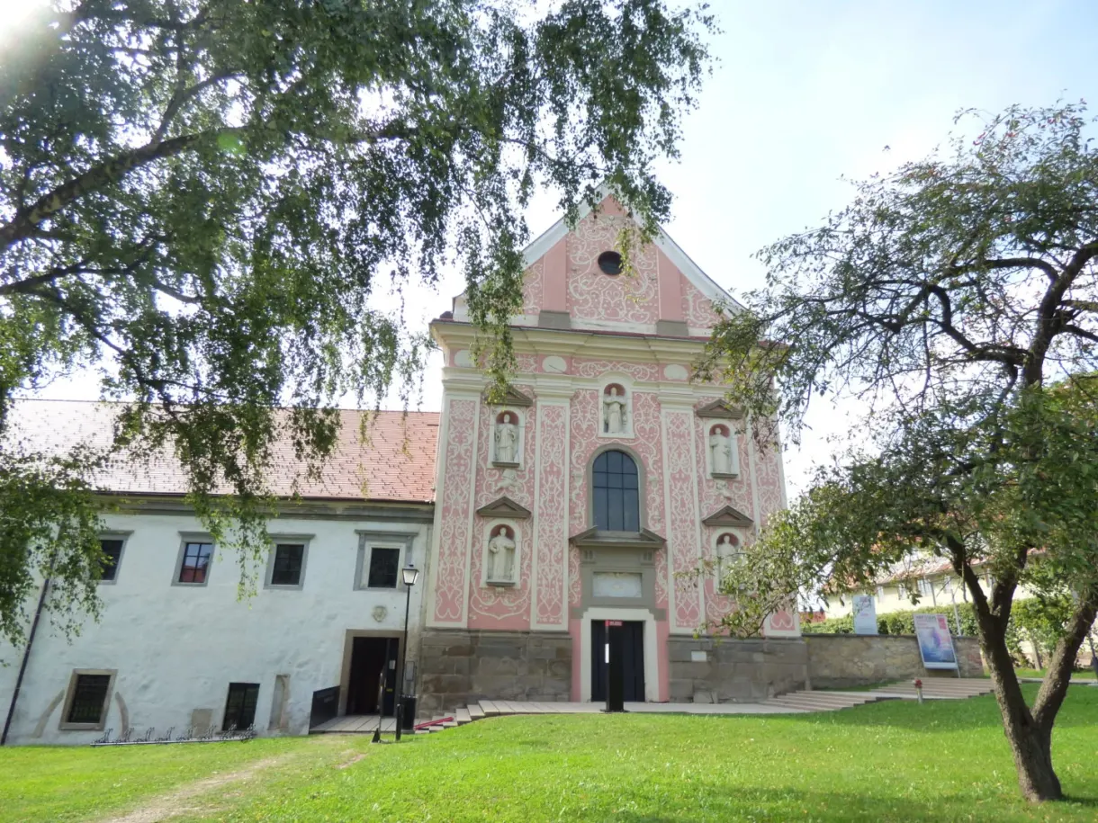 Façade rose d'une église baroque et son monastère