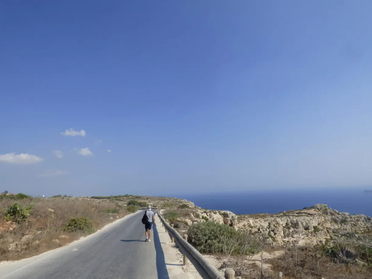 Marcheur solitaire sur la route qui longe la falaise