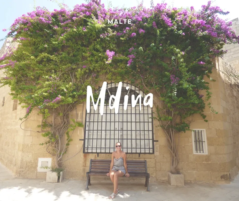 Femme assise sur un banc sous une cascade de bougainvilliers