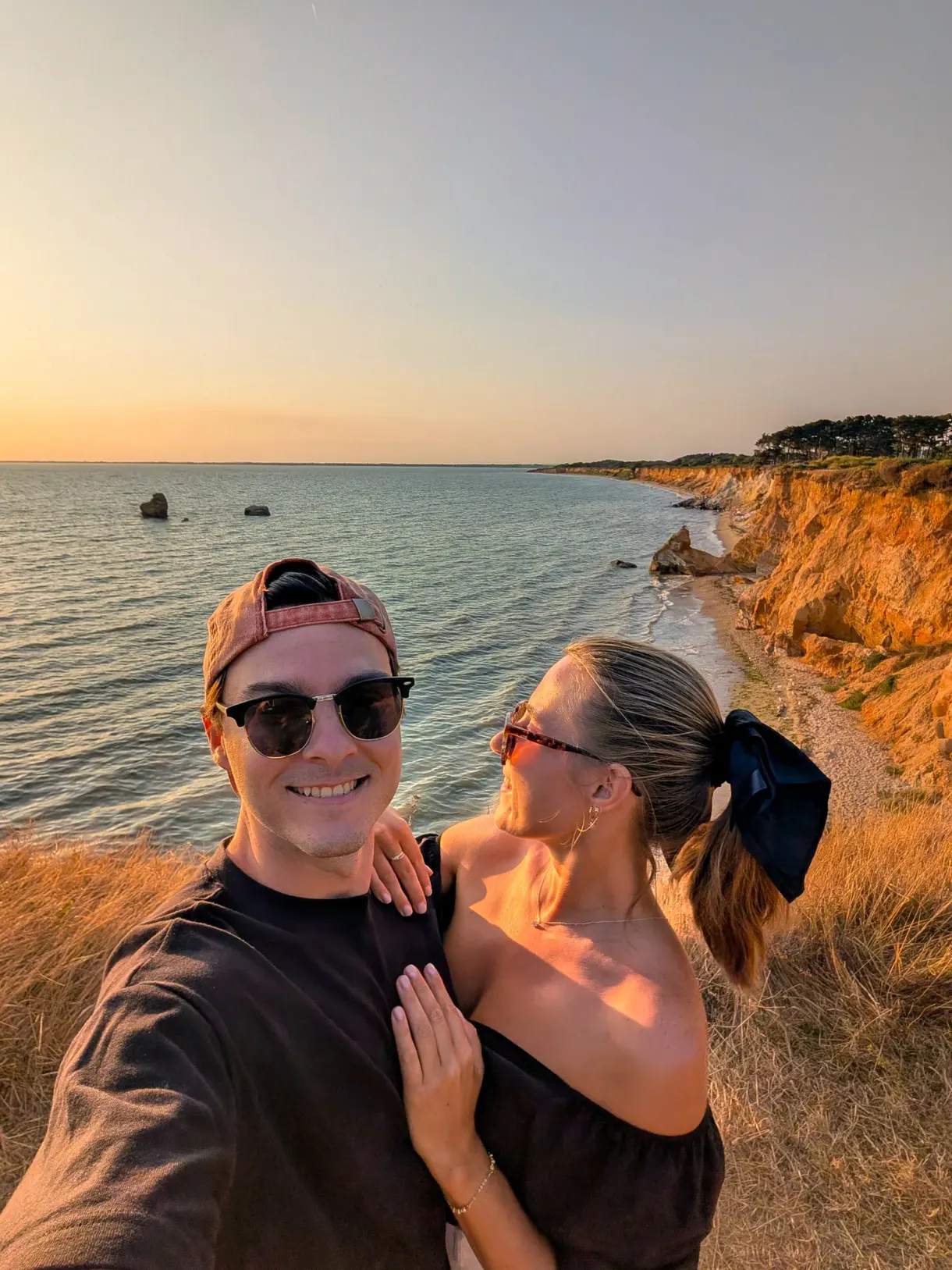 Marie et Romain, les auteurs du blog, au coucher du soleil sur une côte de falaises ocre