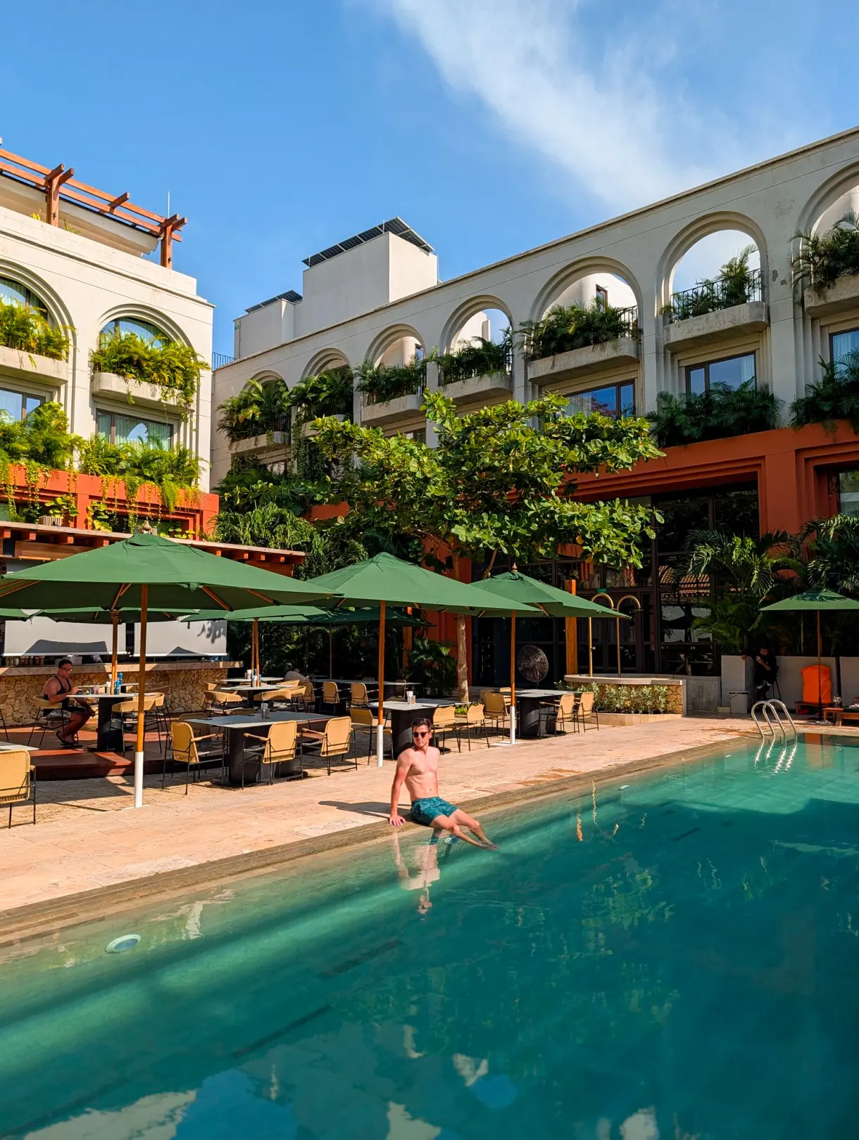 Romain au bord de la piscine d'un hôtel partenaire à arcades et jardins suspendus