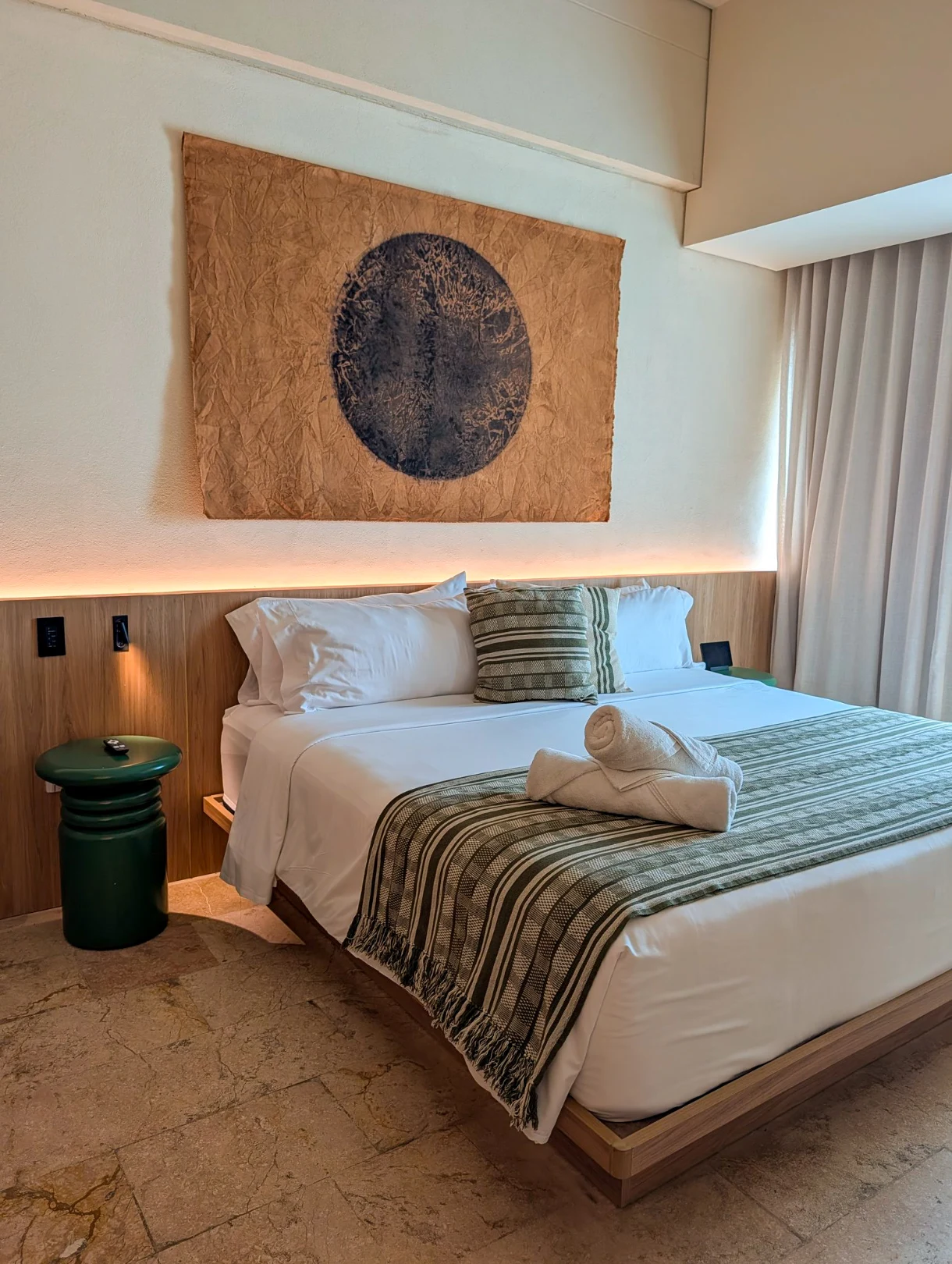 chambre d'hôtel à la décoration épurée dans les tons beige et vert foncé