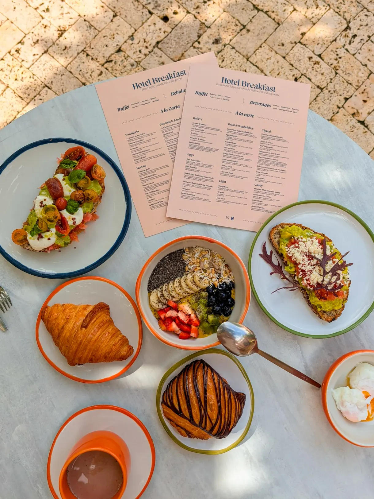 Petit-déjeuner d'hôtel : tartines à l'avocat, bowl de fruits frais et viennoiseries