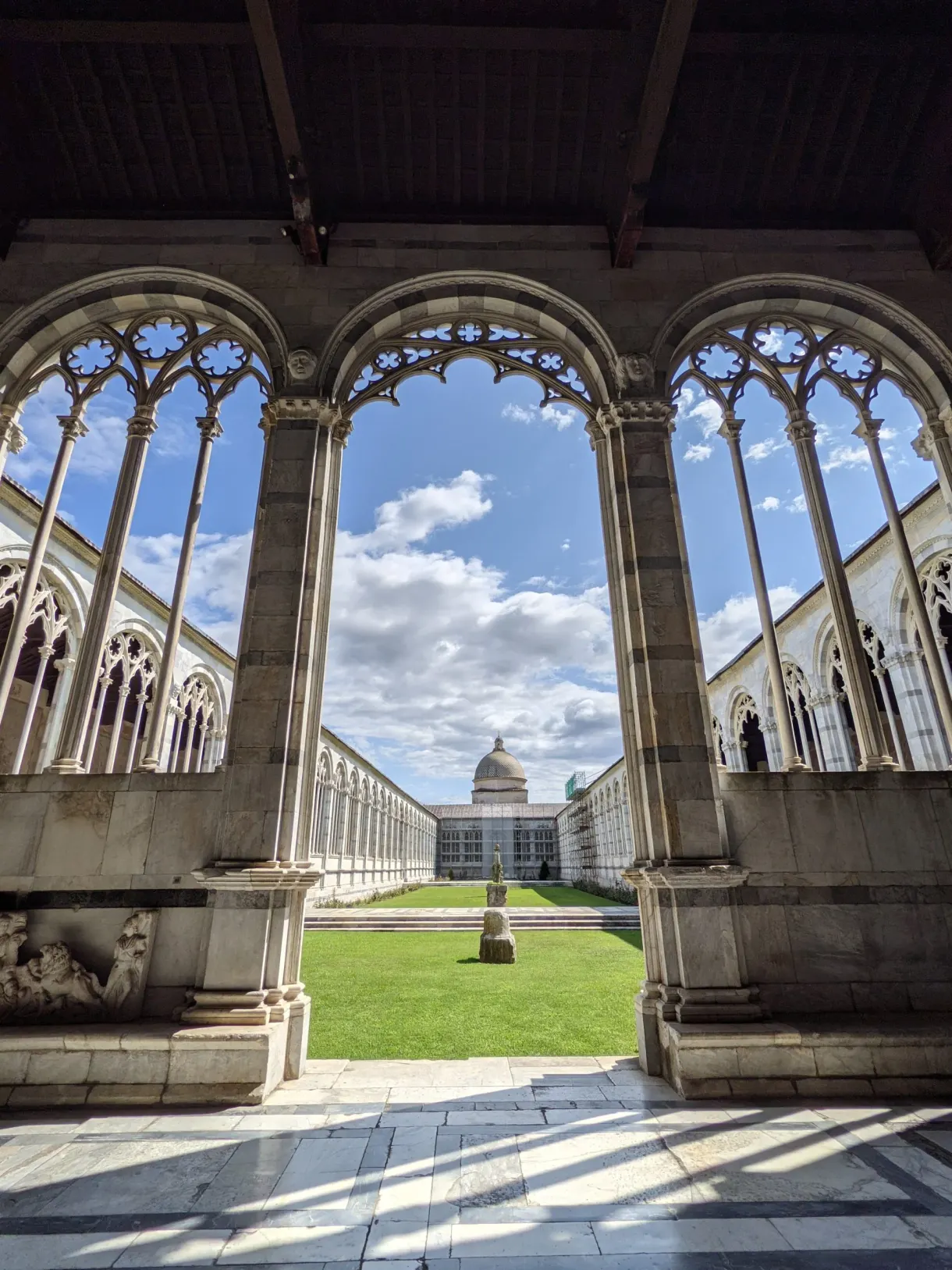 Arcades gothiques ouvrant sur la cour herbeuse du Camposanto