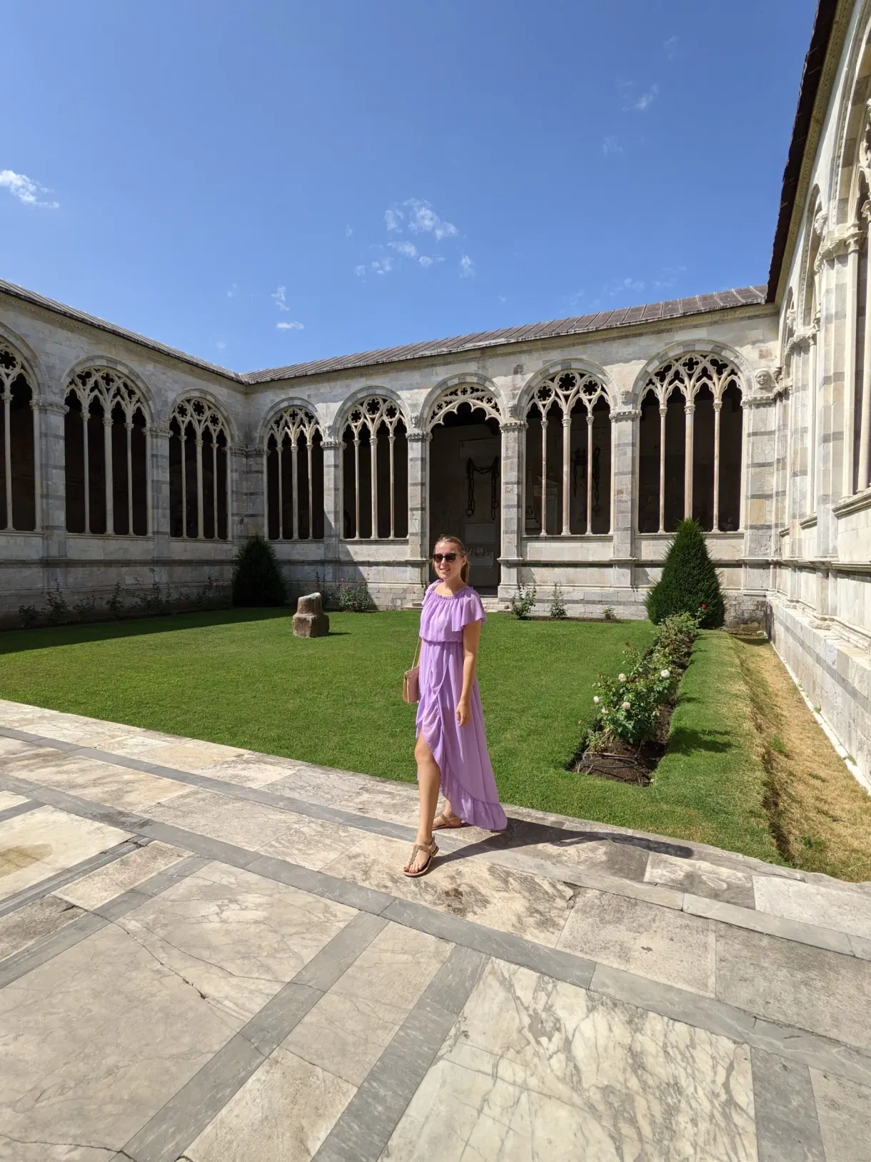 Femme en robe violette dans la cour intérieure du Camposanto
