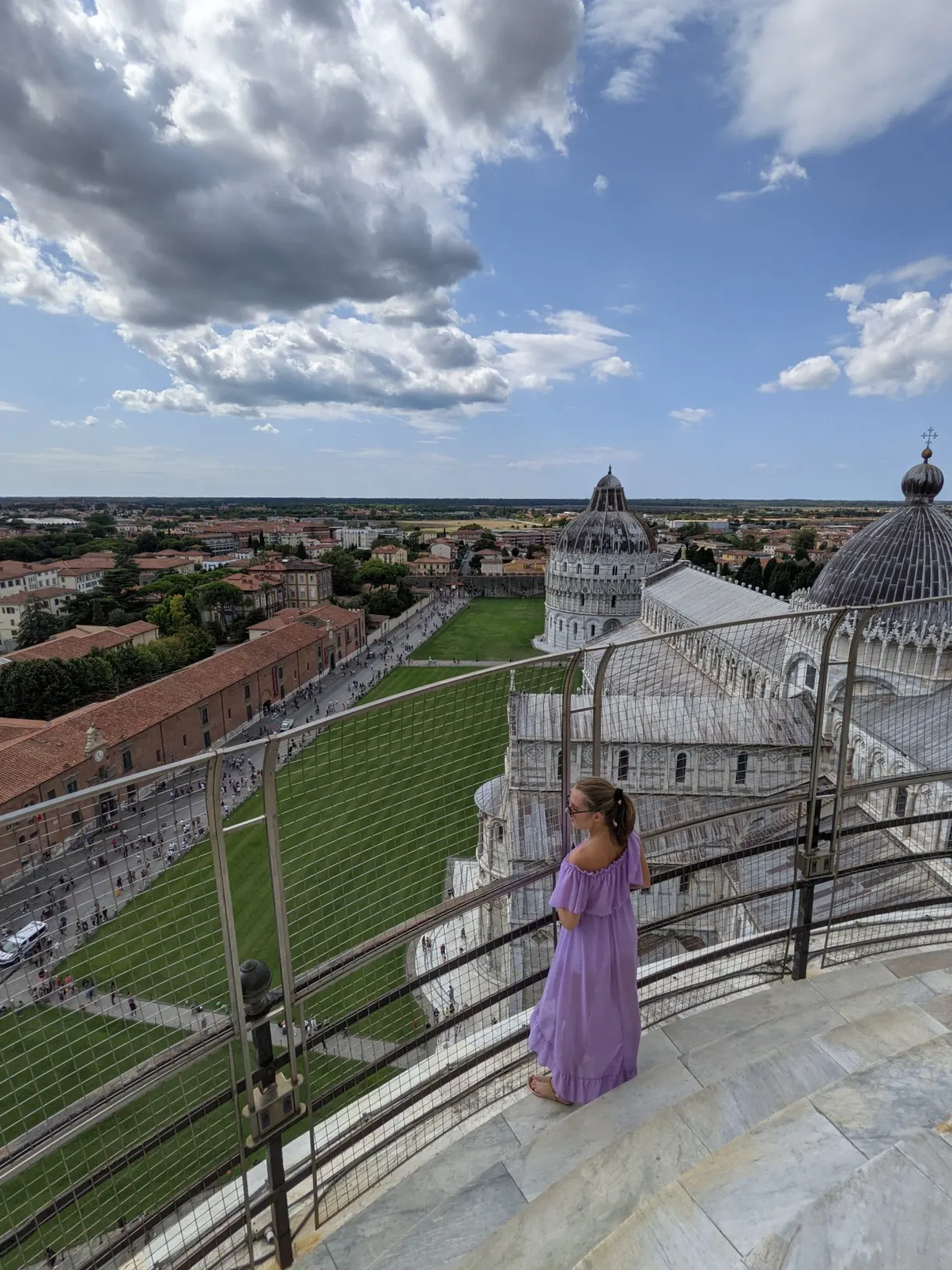 Femme en robe violette au sommet de la tour, place en contrebas