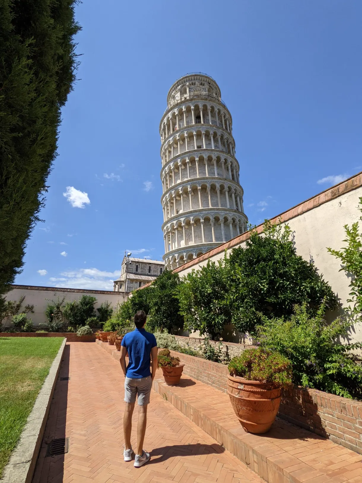 Promeneur dans une allée bordée de pots en terre cuite