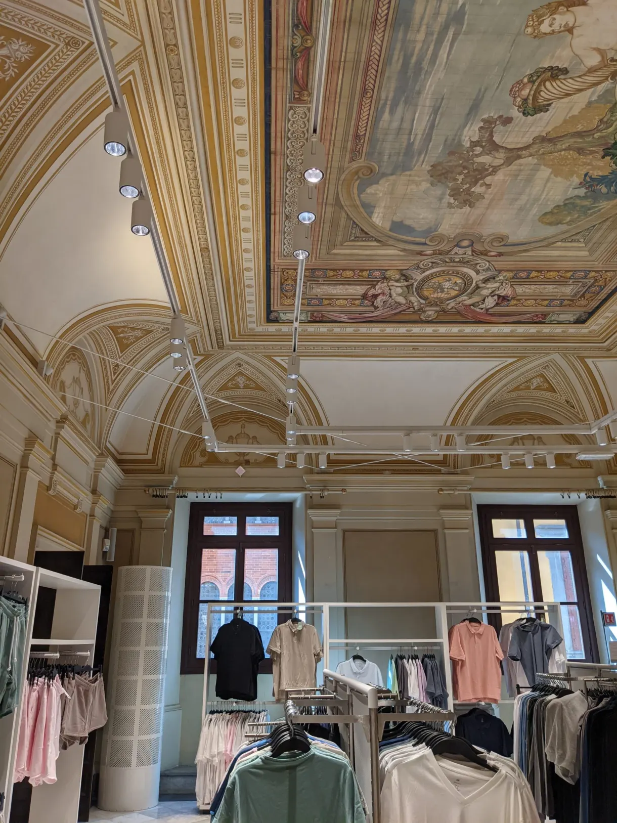 Portants de vêtements installés sous un plafond à fresques