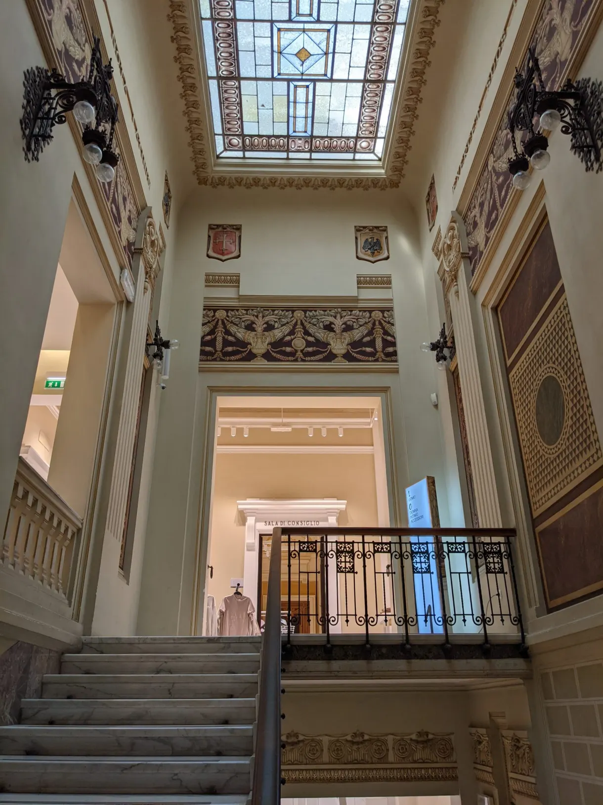 Escalier de marbre montant vers une verrière colorée