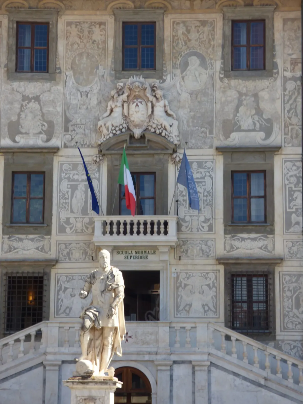 Façade ornée de sgraffites, statue et drapeaux au balcon